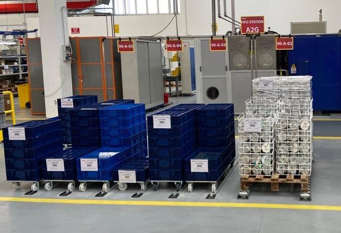 L'immagine mostra una stazione FIFO in un ambiente industriale, con casse blu e pallet organizzati per un efficiente flusso di materiali. Le etichette e le postazioni numerate evidenziano un sistema di gestione dello stoccaggio ordinato e pronto per la produzione. Ideale per comprendere l'uso della metodologia FIFO nell'industria.