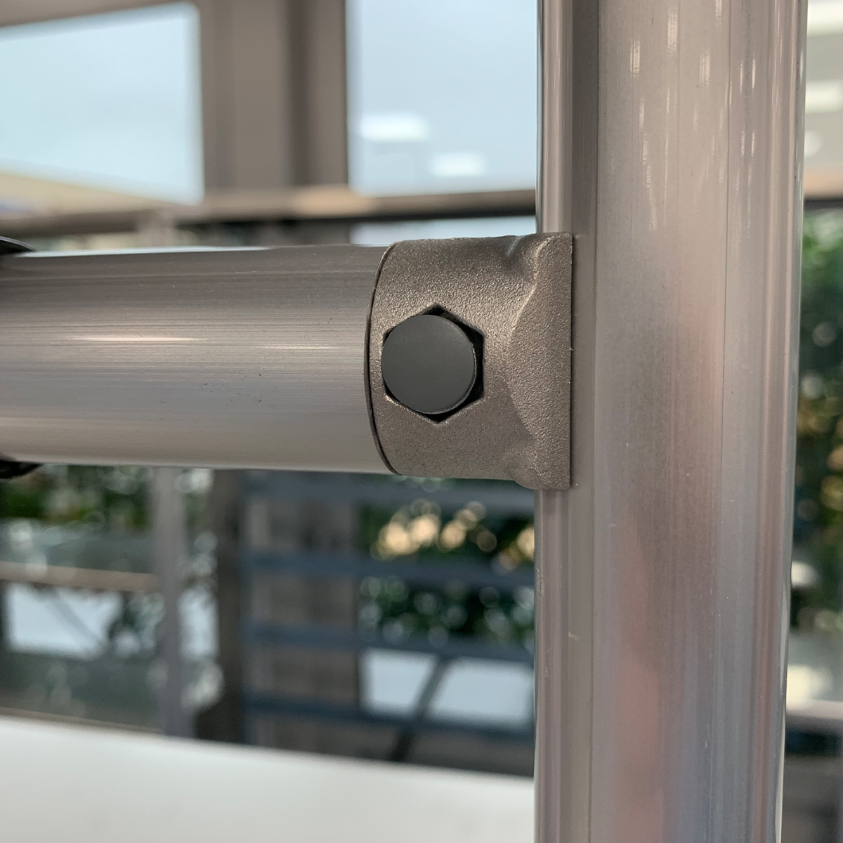 Collegamento Angolare di Profili in Alluminio con Connettore Metallico utek lean dettaglio di un collegamento angolare tra due profili in alluminio. È evidente che i profili siano fissati utilizzando un giunto o connettore angolare in metallo, probabilmente in lega di alluminio o acciaio, con una vite a brugola o esagonale per garantire stabilità e rigidità alla struttura.